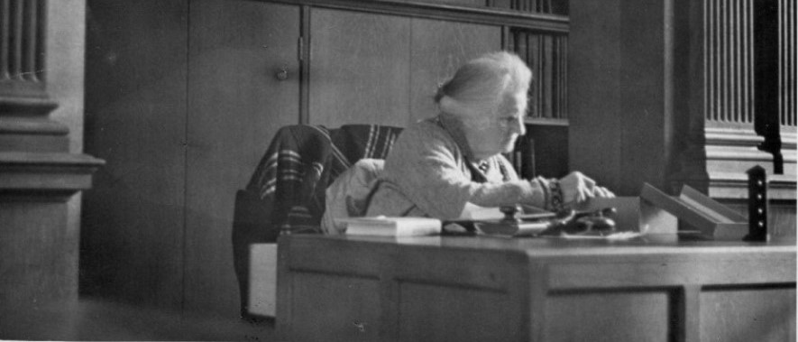 Photograph of Mary cataloguing at the old Marshall Library in Downing Street